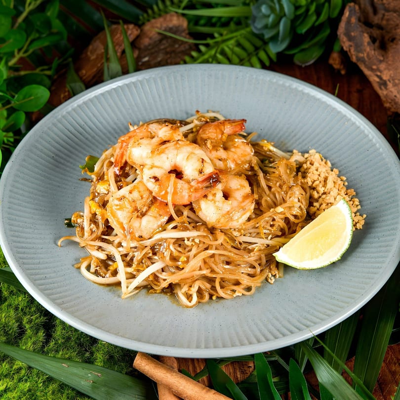Khaosan's Pad Thai with shrimp, noodles, bean sprouts, crushed peanuts, and a lime wedge.